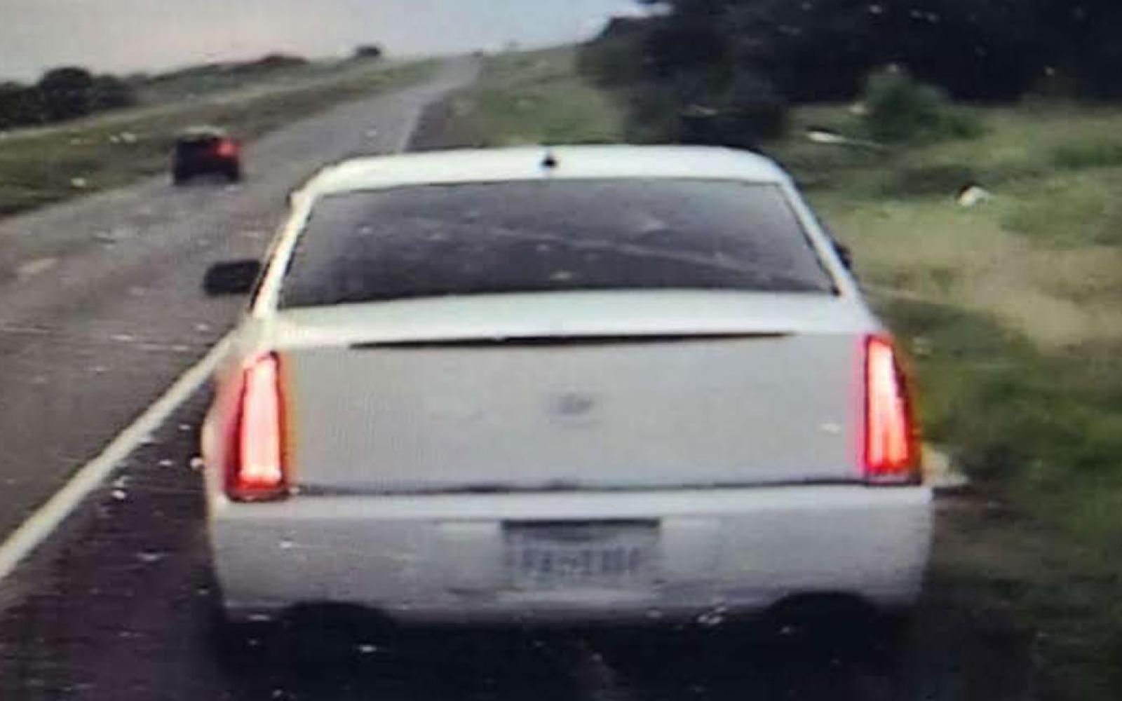 A white Cadillac 4-door sedan with Texas plate FXJ-1334