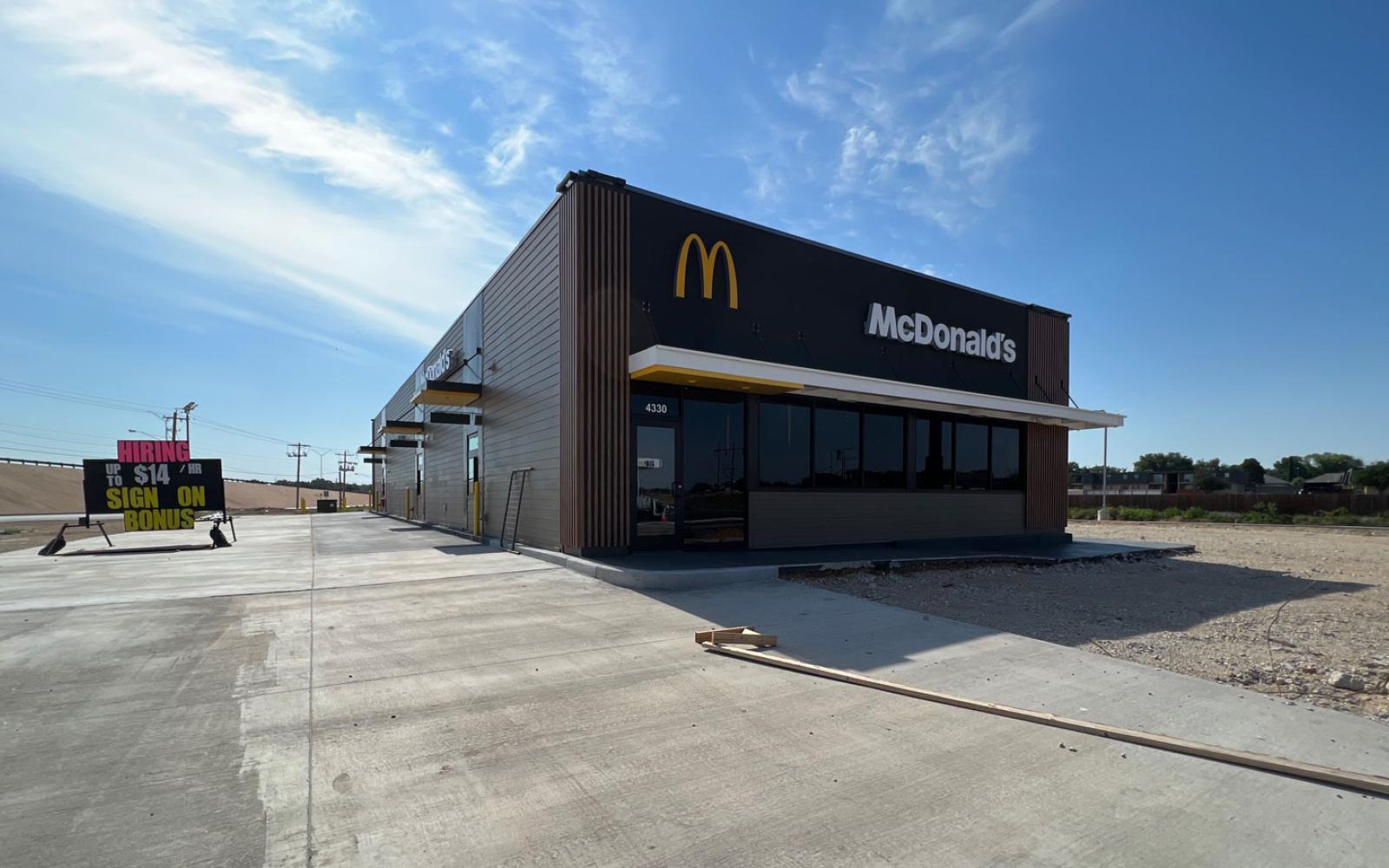 The new McDonalds is ready to open if not for the parking lot issues. Meanwhile, a help wanted sign promises jobs starting at $14 an hour. 