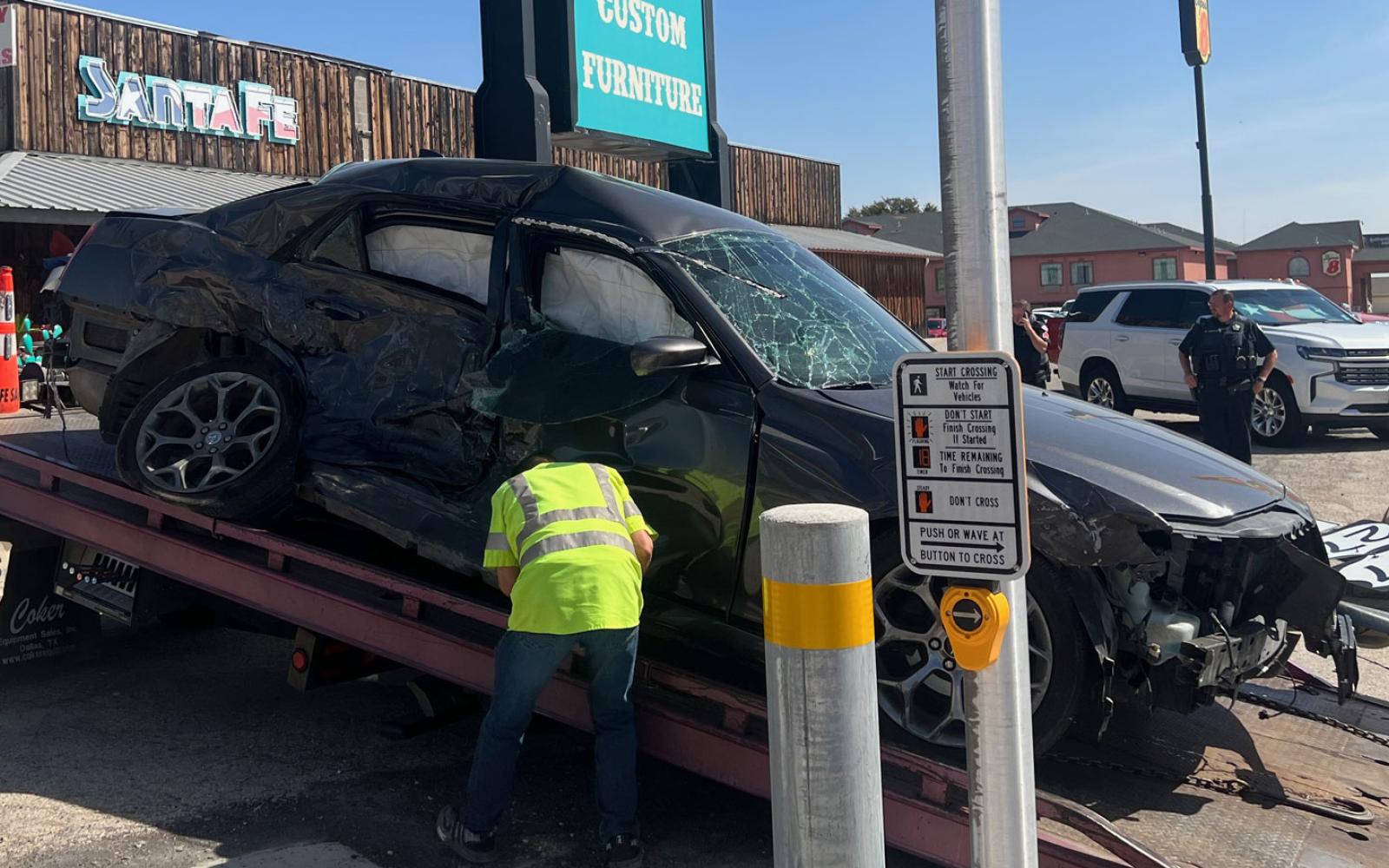 The force of the collision sent the Chrysler 300 careening into the highway sign that had sat unmolested for years in front of Santa Fe Furniture. The sign was knocked halfway down.