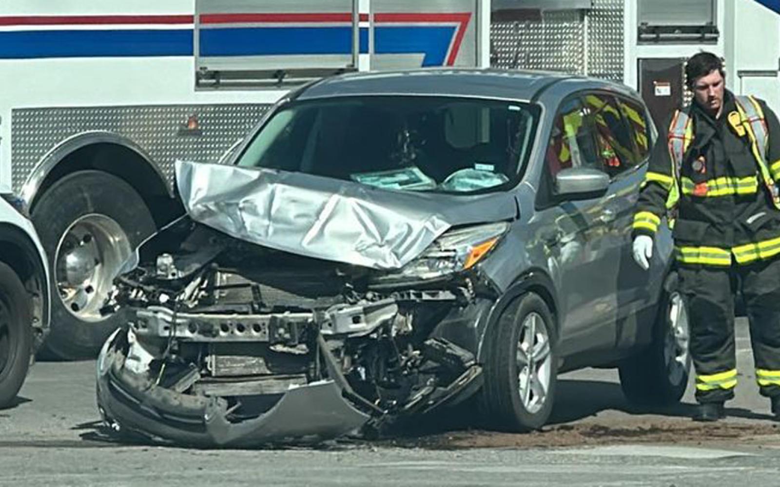 Up close shot of the damage to the silver small SUV