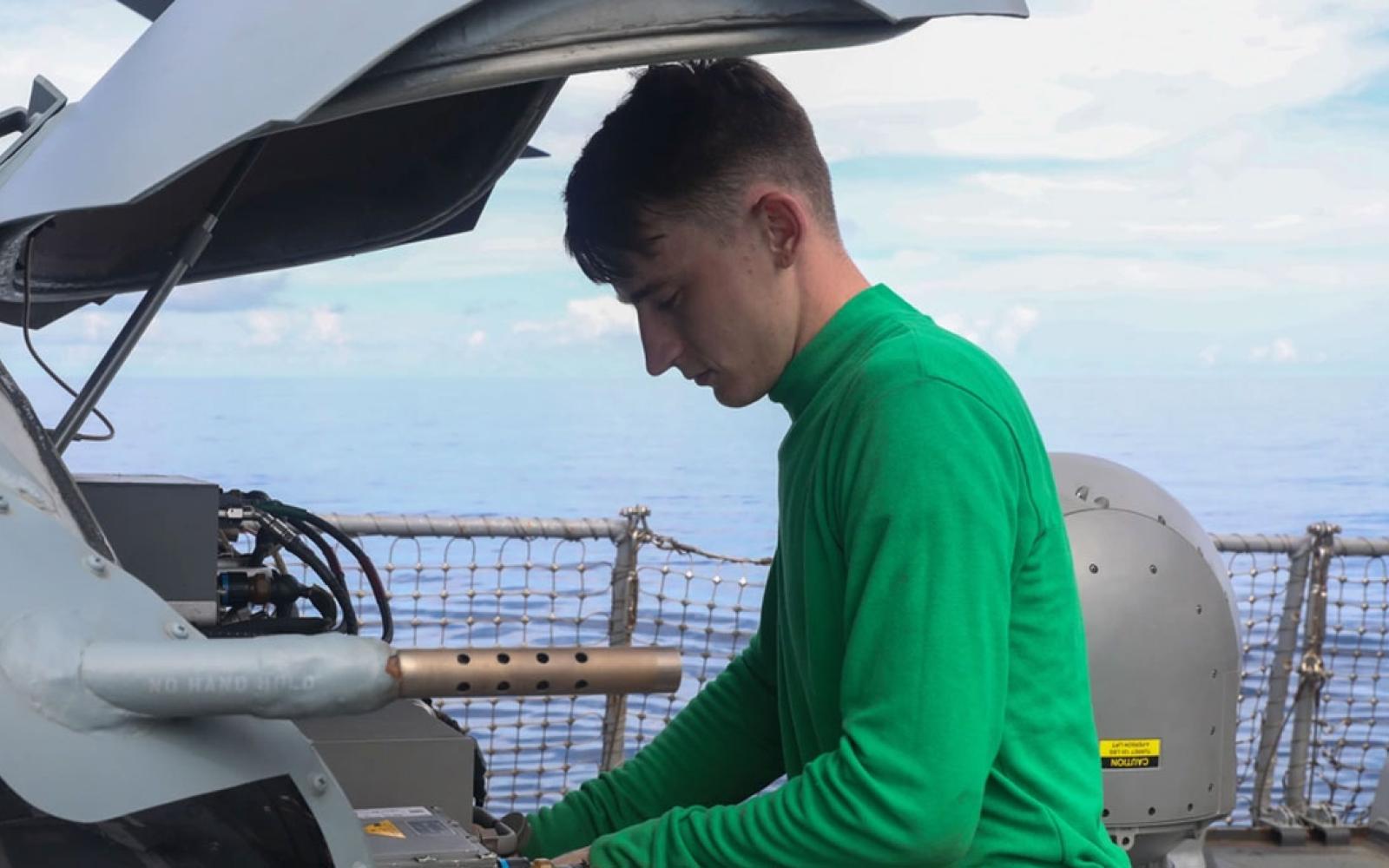 Aviation Electronics Technician 2nd Class Andrew McConnell, from San Angelo, Texas, performs routine maintenance on a Sea Hawk helicopter (MH-60R) 