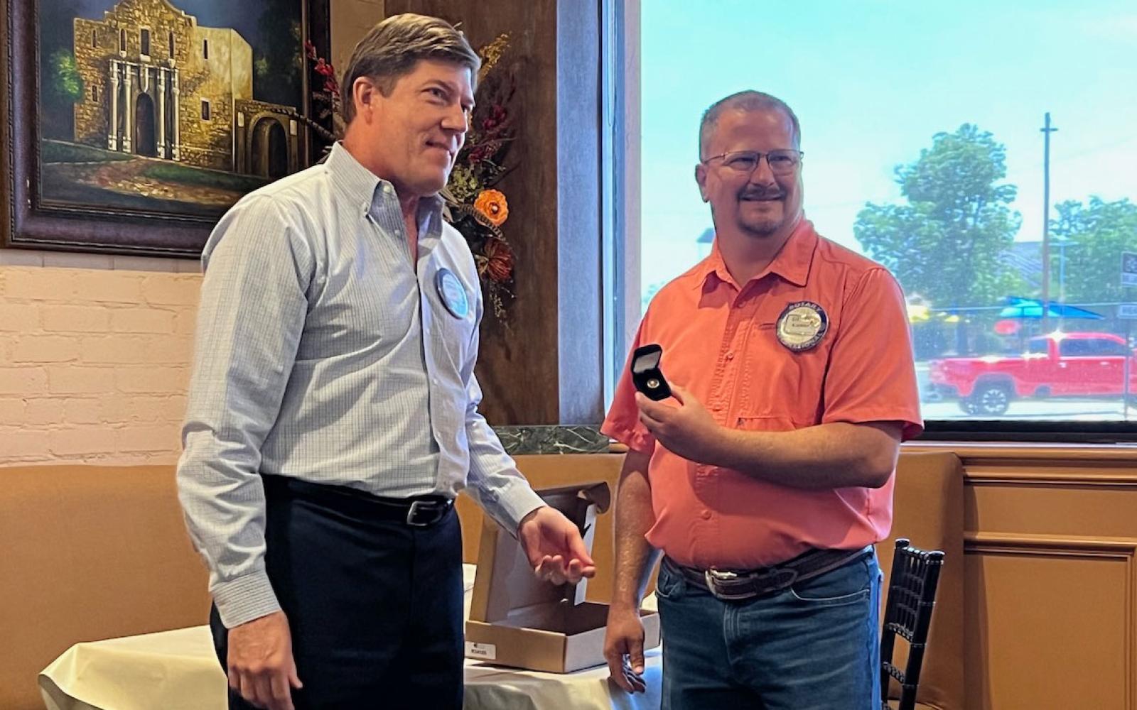 San Angelo Rotary President Ed Yale (L) presents Immediate Past President Devin Koehler with a pin signifying Devin's leadership for the past year.
