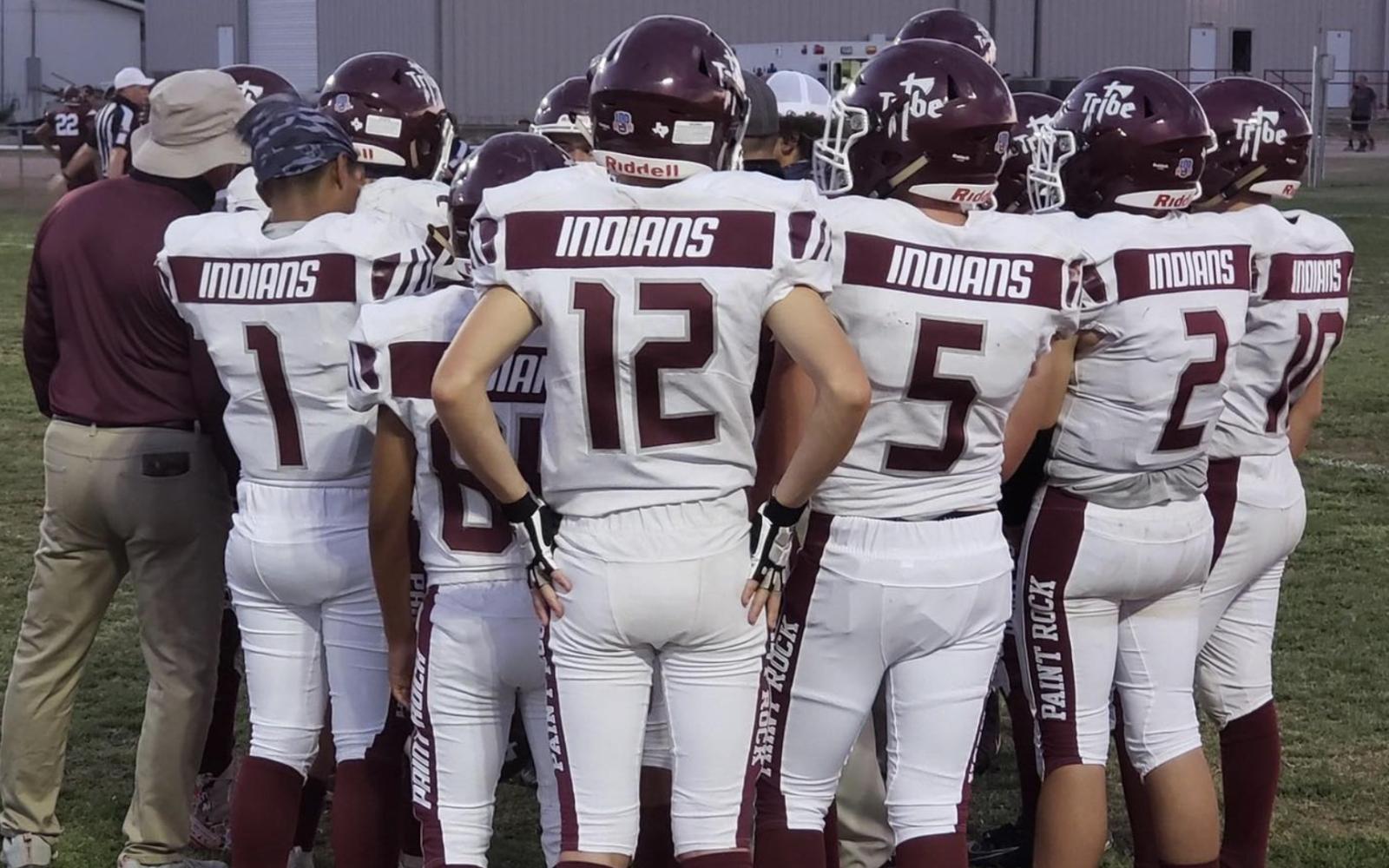 The Paint Rock Indians football team meets with their coach during a game in 2020.