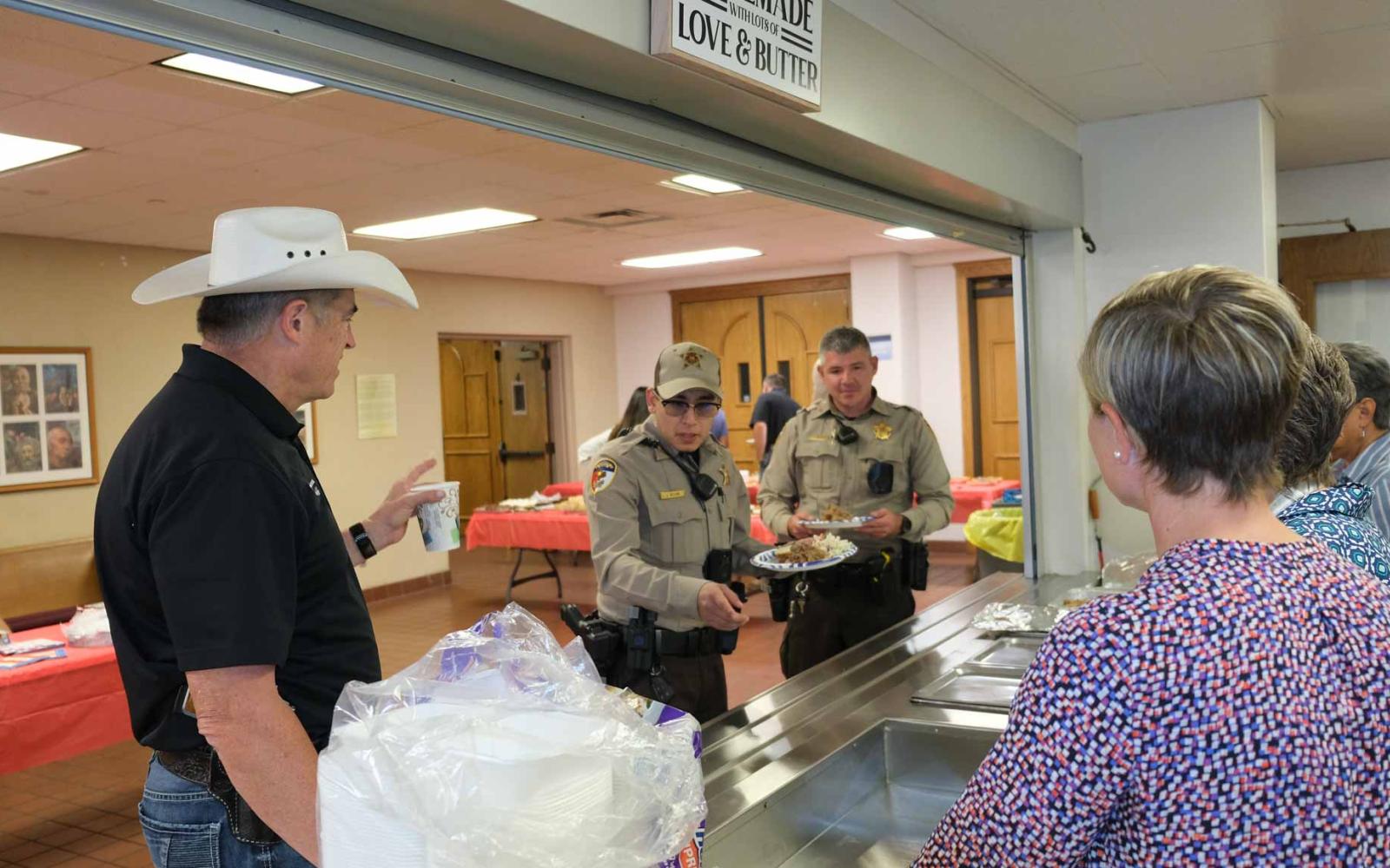 Tom Green County Sheriff Nick Hanna and fellow deputies receive food from members of CVRW. 