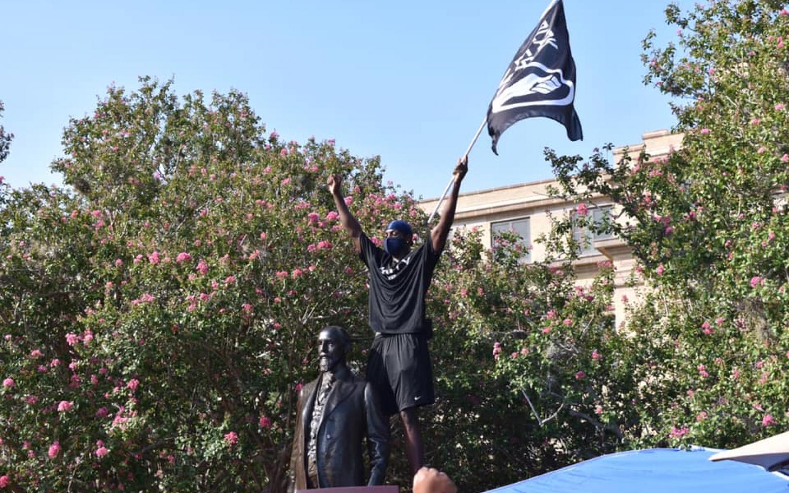 In July 2020, Infinite Tucker, a scholarship track athlete at Texas A&M, rises in protest over the statue of Lawrence Sullivan Ross, 1838-1898. Soldier, Statesman, Knightly Gentleman. Brigadier General, CSA. President of the A&M College.