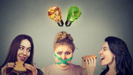 Stressed vegan surrounded by hamburger eaters