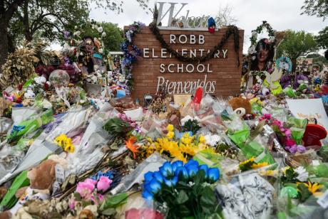 Hundreds of flowers, toys, and candles surround the crosses in memorial of the 21 victims of the Robb Elementary school shooting at Robb Elementary in 2022. Credit: