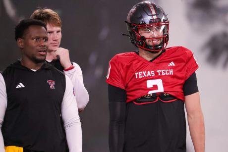 Texas Tech players Brendan Sorbsy (right) and Willi Hammond (back) and assistant quarterbacks coach Lindsey Scott look on during spring football practice at the at the Womble Football Center in Lubbock on April 7, 2026.