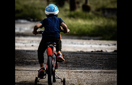 A child is shown riding a bicycle.