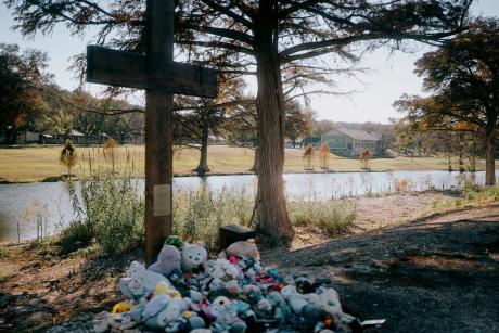 A cross honoring the victims of the July 4, 2025, flood stands in front of Camp Mystic across the Guadalupe River on Nov. 21, 2025.