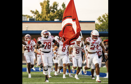 The Carthage football team runs onto the field during the 2026 season.