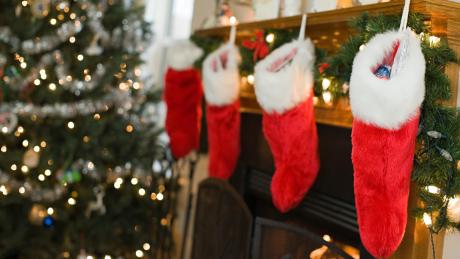 Four stockings hang over the fireplace (photo courtesy of wallpoper.com)