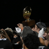 The Water Valley Wildcats hoist a bidistrict playoff trophy after their 62-14 win over Hermleigh on Thursday, Nov. 13, 2025.