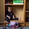A child sits in a bookshelf at Kid's Castle Family Daycare and Preschool in Pflugerville in 2022.
