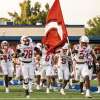 The Carthage football team runs onto the field during the 2026 season.
